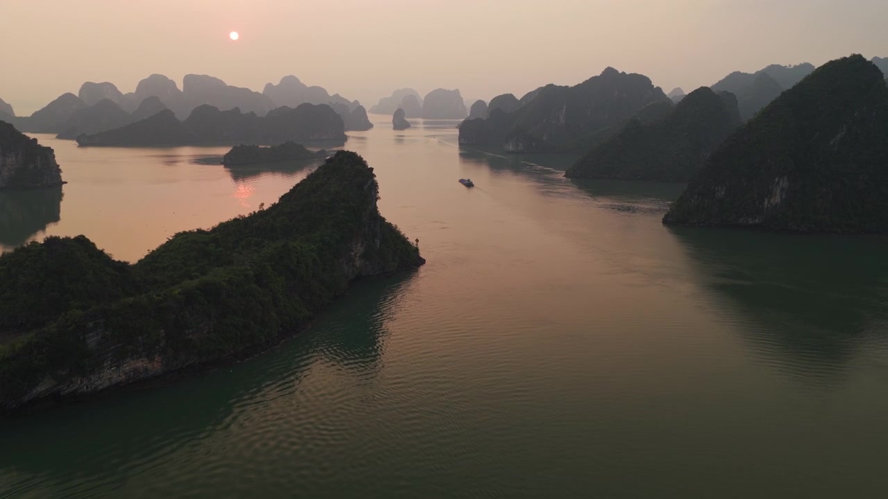 Các khối đá vôi karst khổng lồ ở Vịnh Hạ Long lúc hoàng hôn tại Đông Bắc Việt Nam. Cảnh quay drone từ trên không