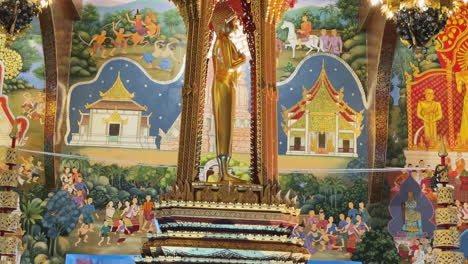 descending view inside wat chedi luang temple, showing statue, golden lights, murals, red and gold roof - thailand
