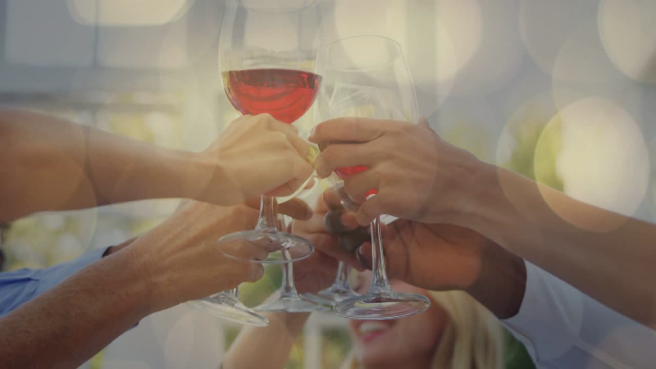 Woman calling toast, friends raising glasses on patio celebrating event, bokeh overlaying glasses