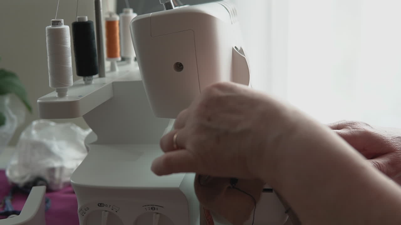 Dressmaker Using Sewing Machine With Cotton Reels. Low Angle, Slow Motion