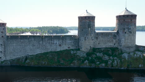 aerial tracking shot of the walls of olavinlinna castle, summer in savo, finland