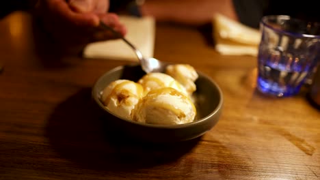 persona comiendo helado con salsa de caramelo