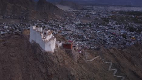 toma de avión no tripulado cinematográfico del monasterio y templo de sankar y la ciudad de leh en el fondo durante la puesta de sol, ladakh, india