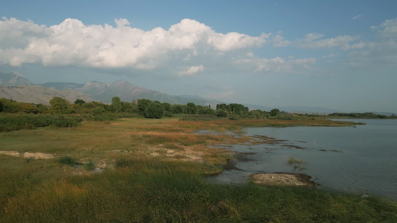 Scenic view of Lake Shkodra with wetlands and mountains in Albania under a blue sky