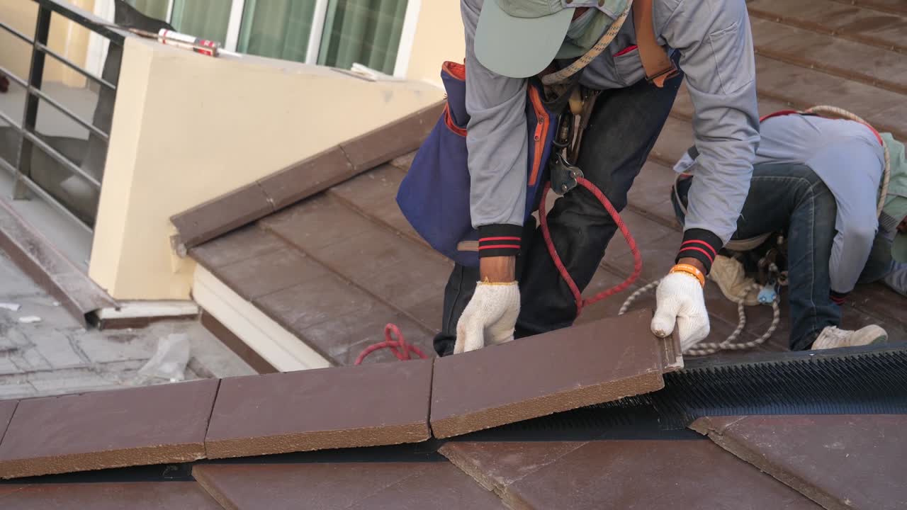 Operaio asiatico che esegue l'installazione del tetto in cantiere, primo piano