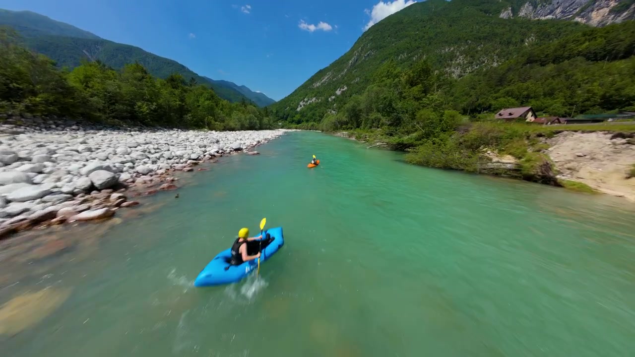 Acqua turchese del fiume Isonzo che scorre attraverso un ampio letto roccioso circondato da montagne verdi in Slovenia. - Ripresa aerea FPV