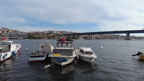 boats docked in istanbul harbor with bridge in background