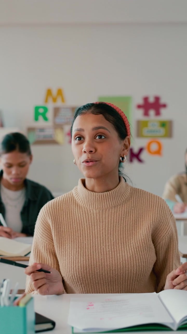 Young Student Raising Hand to Ask Question in Classroom