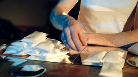 in the underground laboratory hardcore dealer places brick packs filled with drugs into the suitcase for further selling and distribution. criminal business