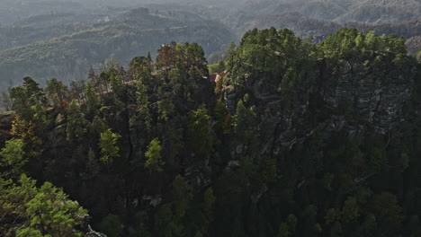 Hrensko-Czechia-Aerial-v4-low-drone-flyover-hillside-Pravcicka-Archway-and-Falcon's-Nest-capturing-spectacular-rock-formations-and-burnt-forest-views---Shot-with-Mavic-3-Cine---November-2022