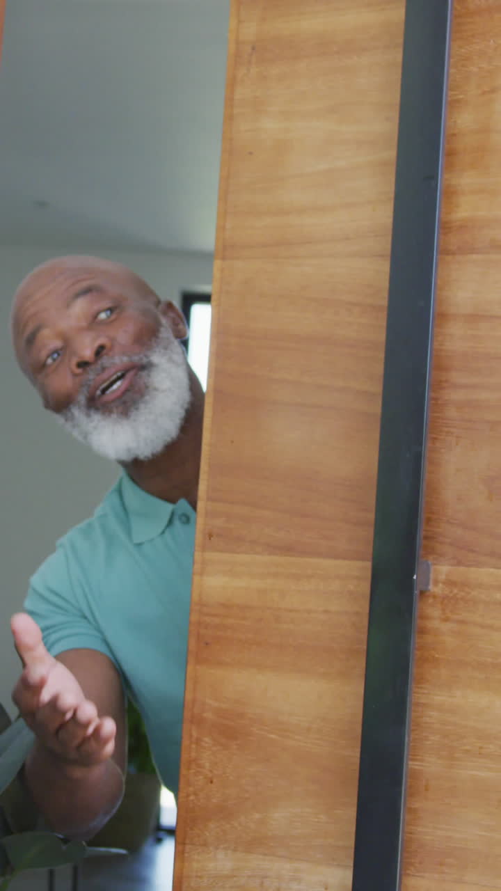 Portrait of happy senior african american man opening door at retirement home