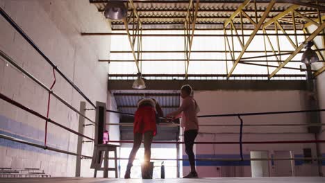 two mixed race women discussing in boxing ring