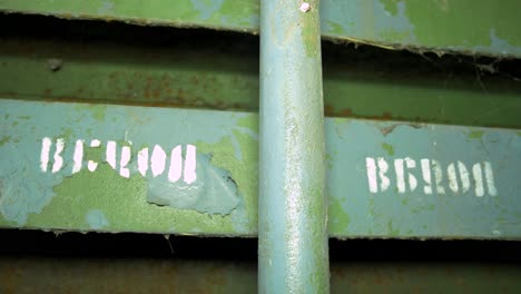 old steel door inside the concrete bomb shelter to hide civil people, an underground apocalypse bunker built in old coastal fortification, white text in russian exit , handheld closeup shot