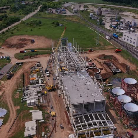 construction area of the future granary complex. building of a new modern grain elevator plant near the railways. circle aerial view over the site