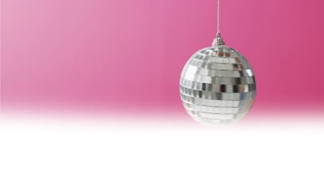 Animation-of-disco-ball-spinning-on-pink-background