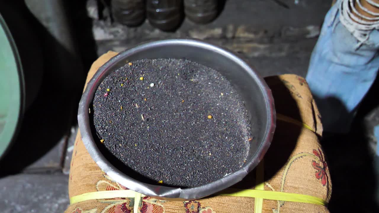 인도네시아에서 크루푸크 생산을 위해 준비된 은 검은 모래의 느린 동작 촬영