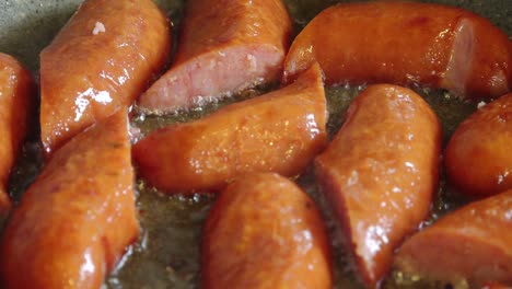 slices of dried sausage sizzle in a hot pan, releasing savory aromas