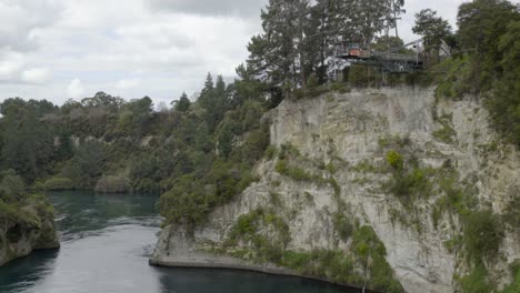 a static wide shot of someone doing the giant swing over the waikato river in taupo, nz