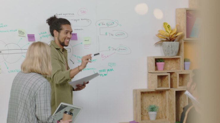 creative team meeting mixed race businessman presenting project development strategy on whiteboard diverse group of business people working together sharing ideas enjoying leadership support