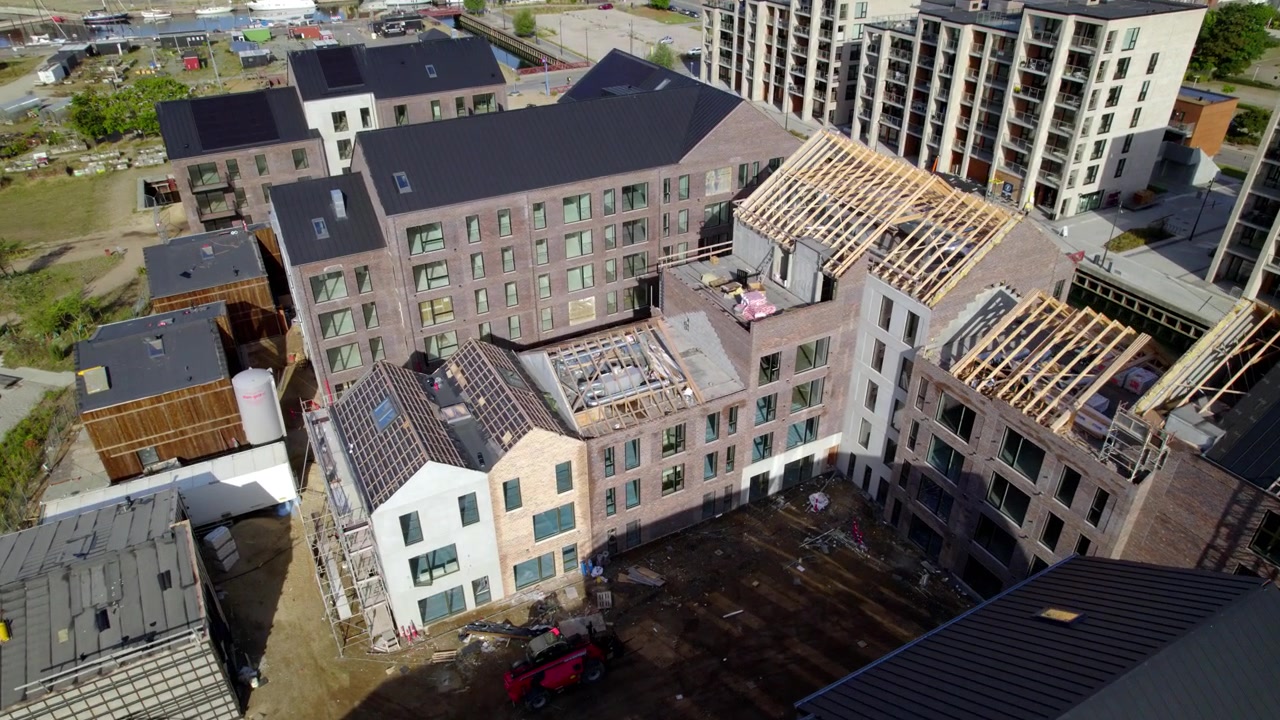 Vue aérienne d'un chantier de construction actif situé près d'un port au Danemark.