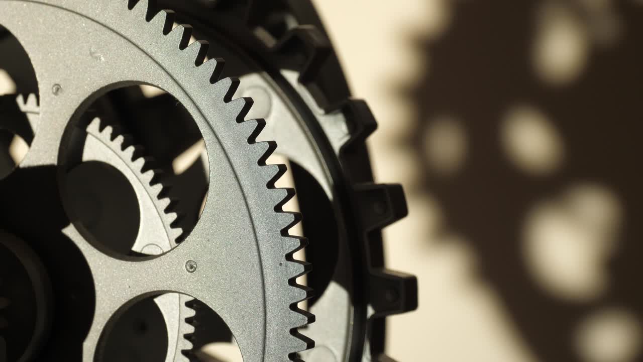 Close up cogwheels of an industrial looking clock shadows