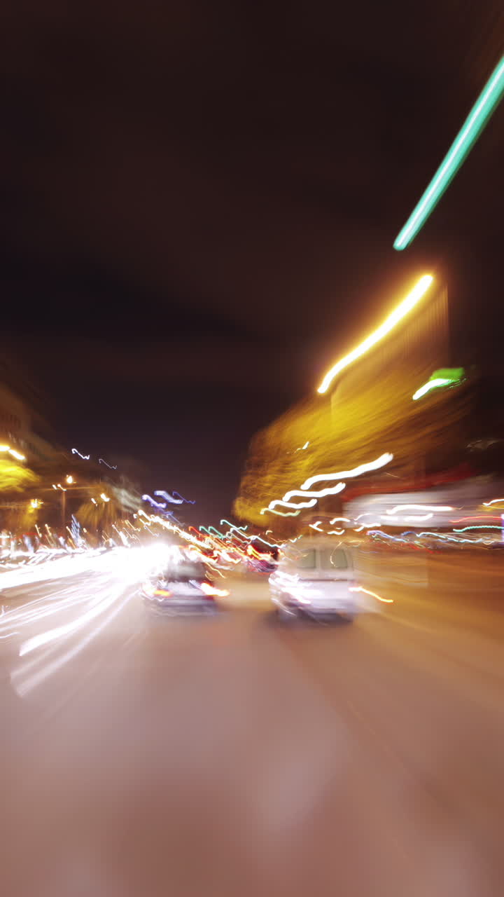 guidare intorno a barcellona di notte con le luci della città e il traffico in verticale