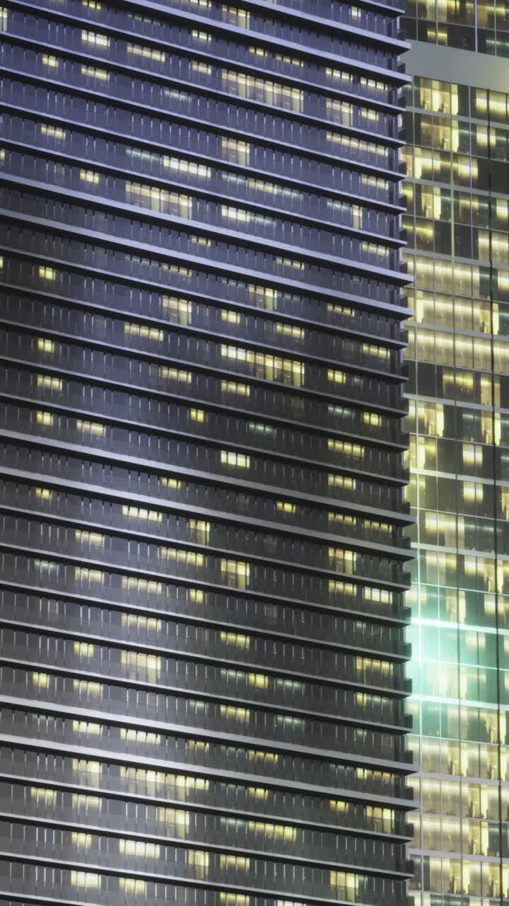 Evening glass frontage displaying lit floors and architectural rhythm