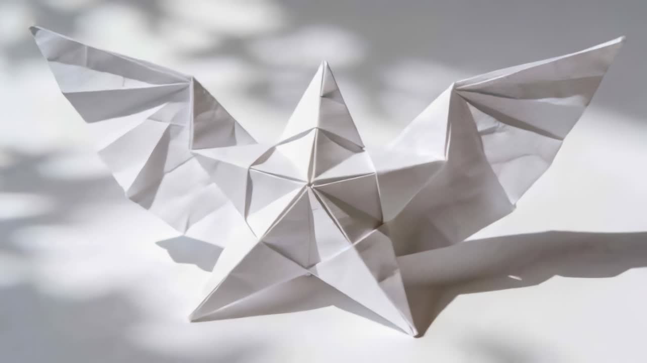 Shifting white origami sculpture moving forward on white tabletop, sunlight casting dappled shadows