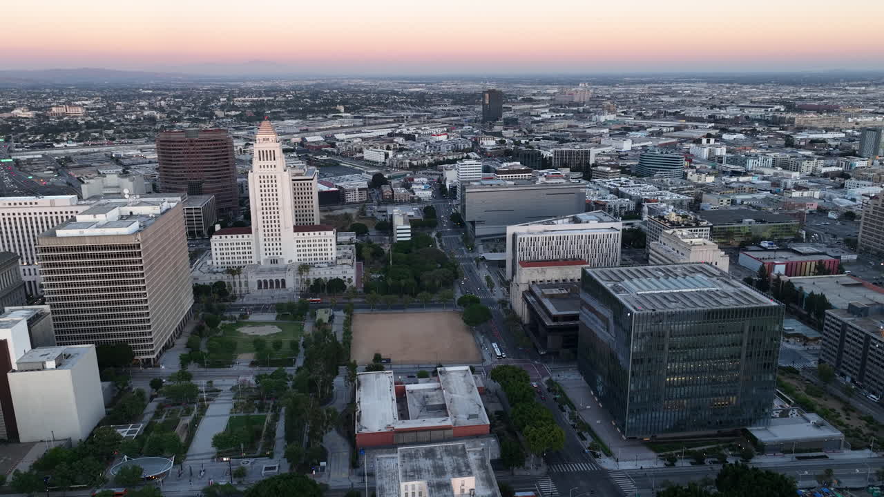 Aerial pan shot of the Los Angeles City Hall and downtown LA,, colorful dusk sky