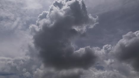 time lapse of fast moving swirling afternoon storm clouds against a backlit blue sky