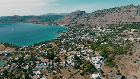 drone flight over holiday resort pefkos next to idyllic turquoise ocean, rhodes