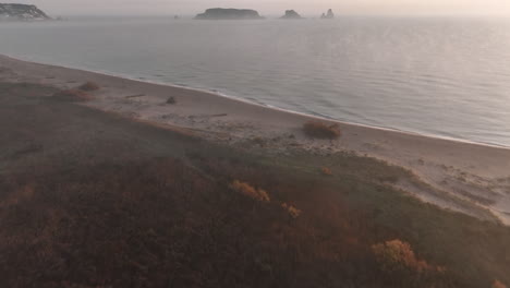 aerial tilt up over costa brava in foggy morning, medes islands in background