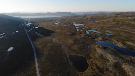 Mountain-road-leading-towards-a-lake-in-Southern-Norway