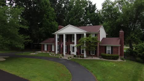 Aerial-Drone-Footage-Orbiting-a-Large-House-With-Columns-in-a-Luxury-Neighborhood