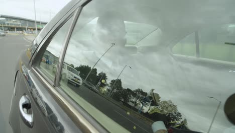 a pilot sits in a black car that drives him to airport