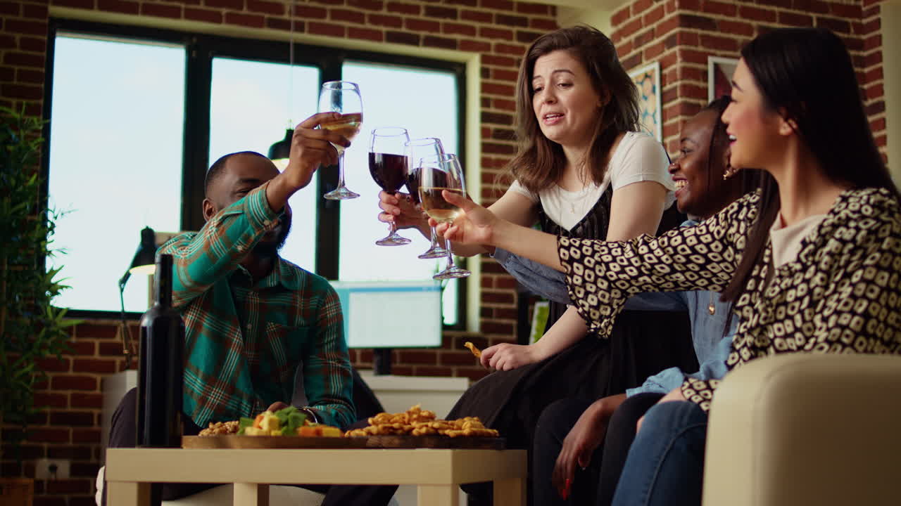 Multiracial group of friends talking with each other in brick wall apartment living room