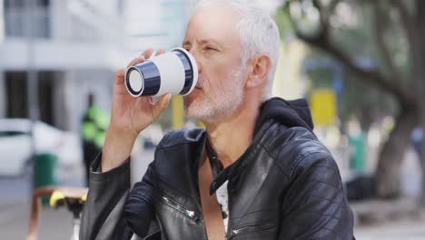 hombre caucásico fuera y alrededor en la calle de la ciudad bebiendo un café