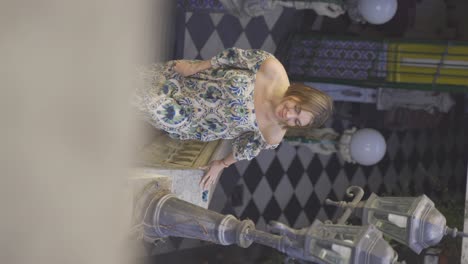 a handheld vertical footage of a young woman climbing the baroque styled stairs towards the camera as she wanders around