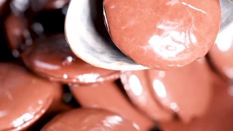 cuchara agitando discos de chocolate brillantes en el cuenco