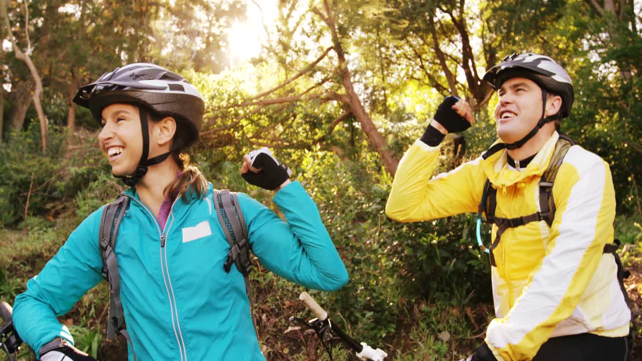 una pareja de ciclistas de montaña apretando el puño.