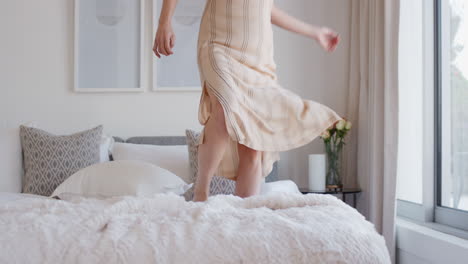 Mujer-Feliz-Saltando-En-La-Cama-En-La-Habitación-Del-Hotel-Divirtiéndose-Disfrutando-Del-Estilo-De-Vida-De-Vacaciones-Celebrando-La-Libertad