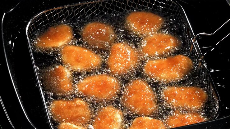 Golden Brown Chicken Nuggets Deep Frying in Hot Oil