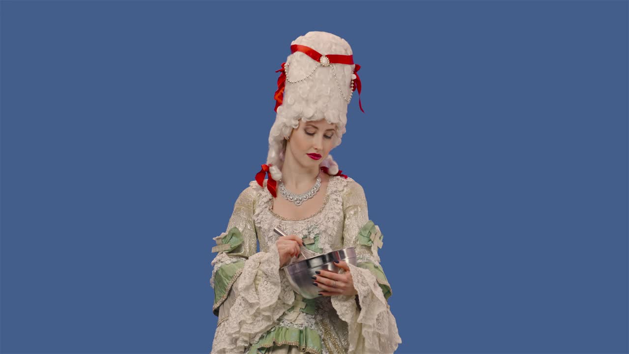 빈티지 렌즈 드레스와 위그를 입은 궁정 여인의 초상화, 음식을 준비하고, 그에 무언가를 휘두르고, 청녀가 블루 스크린 배경으로 스튜디오에서 포즈를 취하고, 클로즈업, 슬로 모션 준비 59.94fps