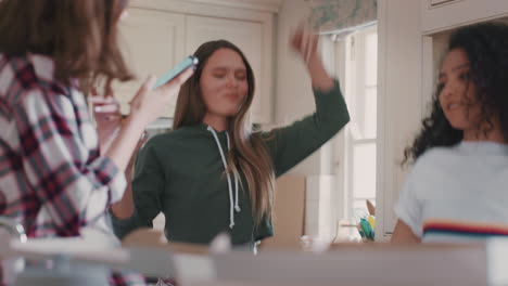 happy teenage girls dancing in kitchen eating pizza having fun celebrating together enjoying hanging out on weekend