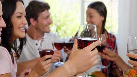 amigos felices alegrándose con vino rojo