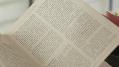 Woman's-Hand-Turning-Pages-Of-A-Book---close-up,-selective-focus