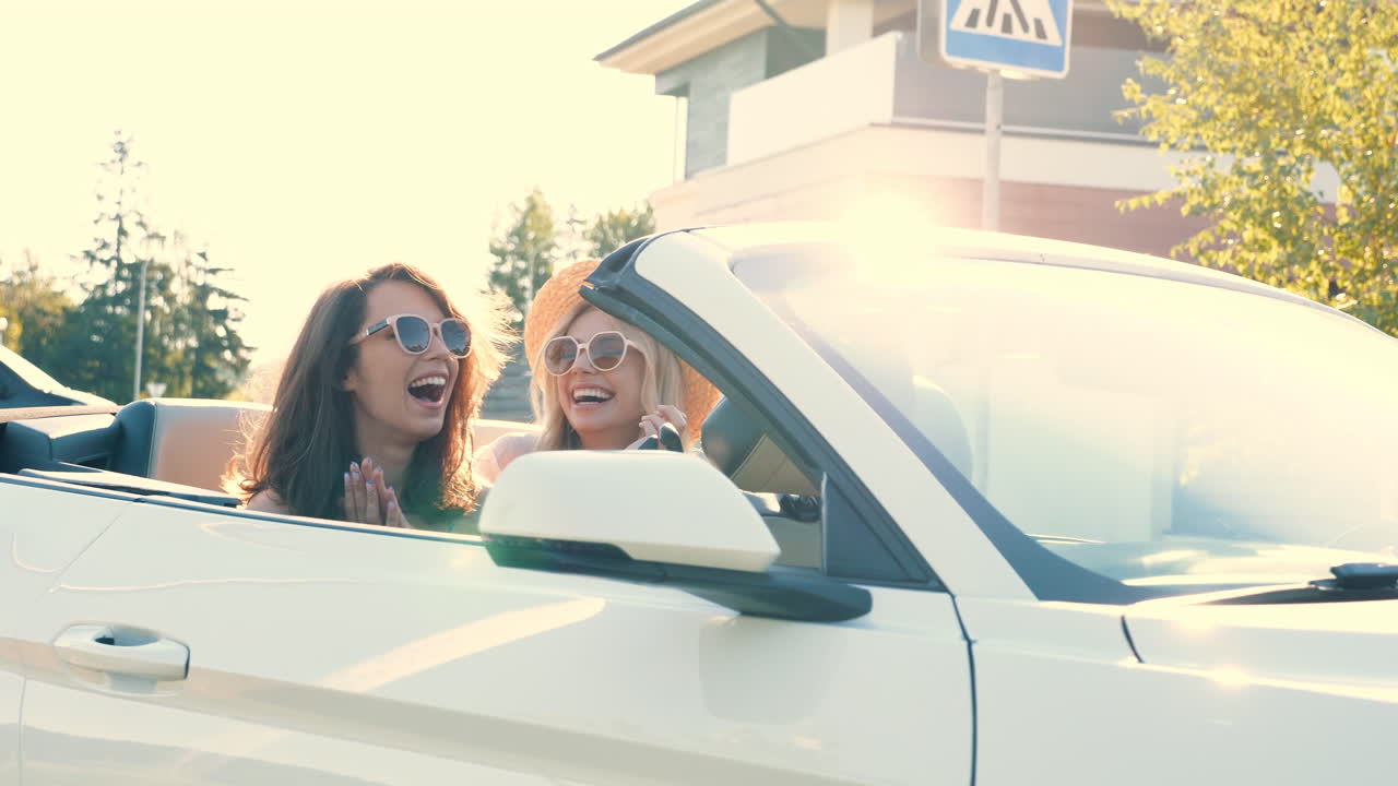 dos mujeres divirtiéndose en un coche convertible