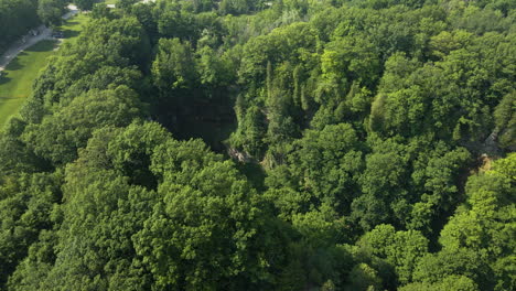 Drone-dolly-tilt-in-reveals-Tew-falls-hidden-off-from-Ontario-Canada-highway