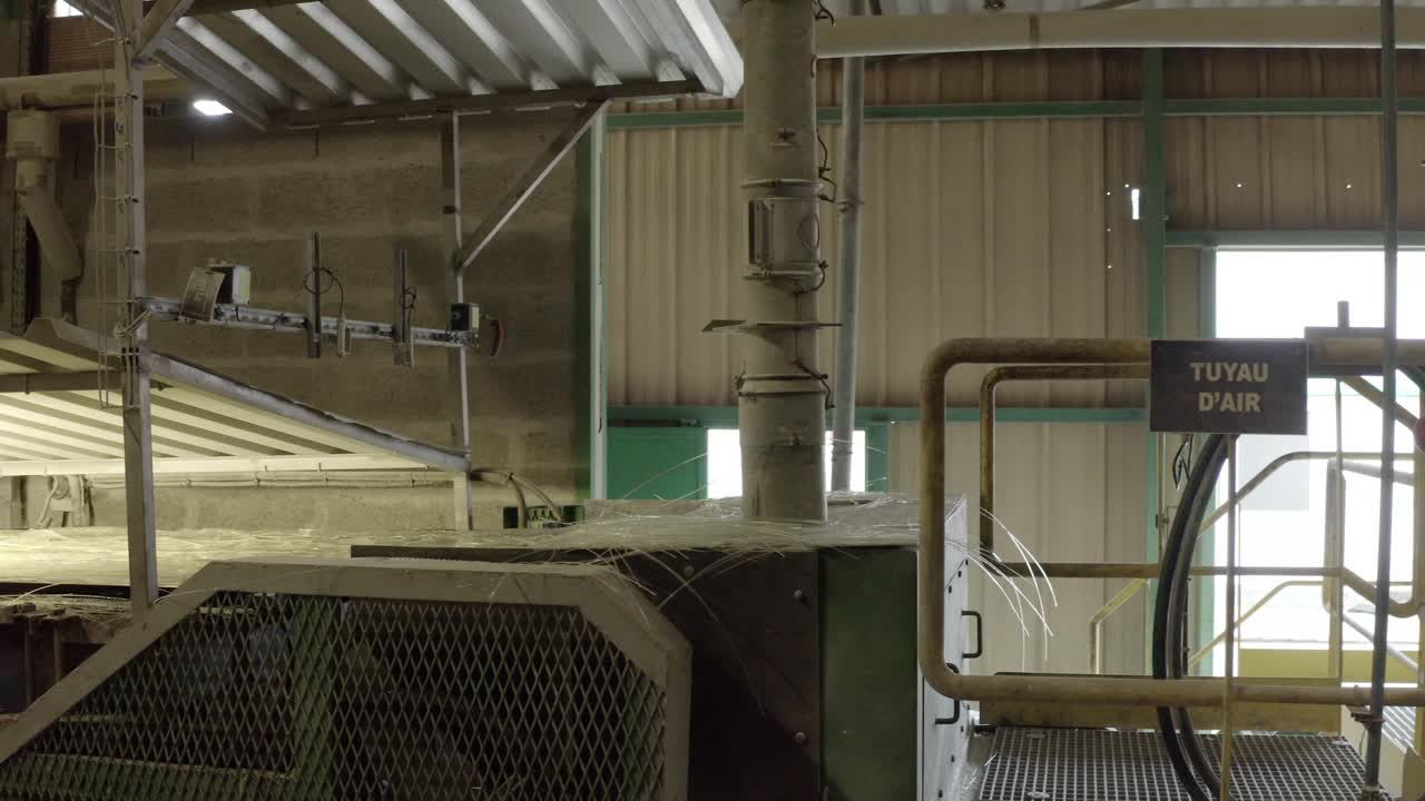 POV drone footage exploring interior of large industrial plant, showcasing machinery, pipes, and infrastructure in Veille-Saint-Girons, France