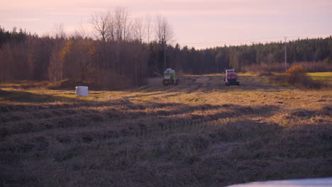 crane shot of a harvester and a tractor, harvesting on a wheat field, on the countryside, on a sunny, autumn evening, in soderhamn, sweden